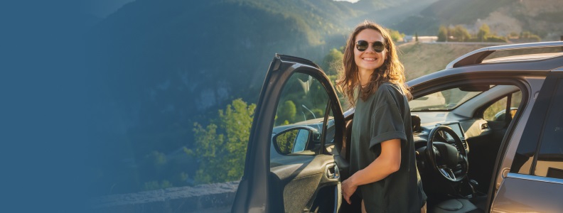 Woman getting out of a car on a mountain overlook