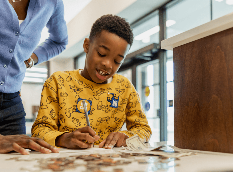 Young boy making FAT CAT deposit