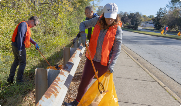 Volunteers picking up trash on the side of the road