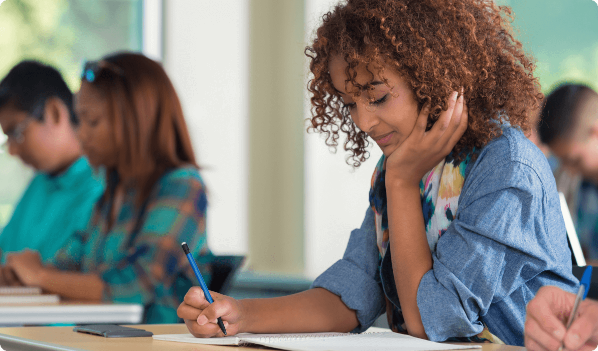 teen with pen in school at desk
