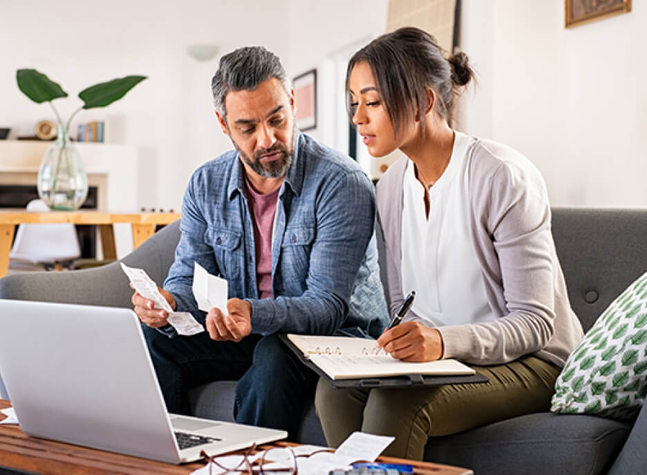 man and woman with paperwork on couch