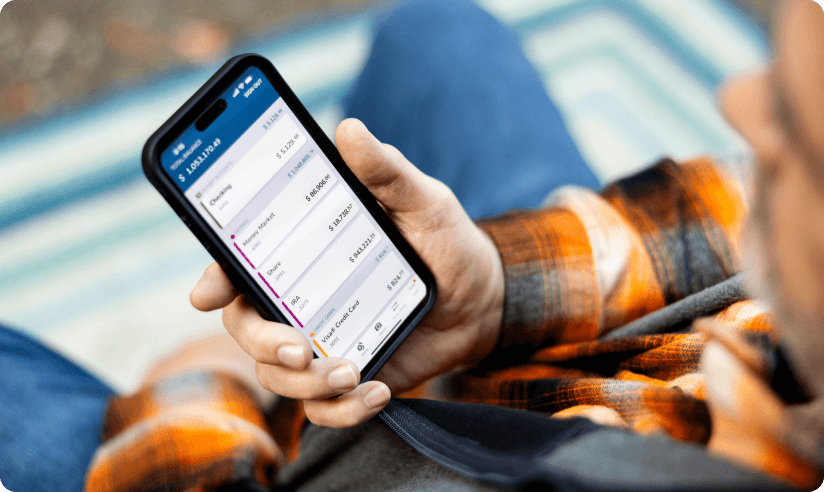Man holding a phone displaying the SECU app
