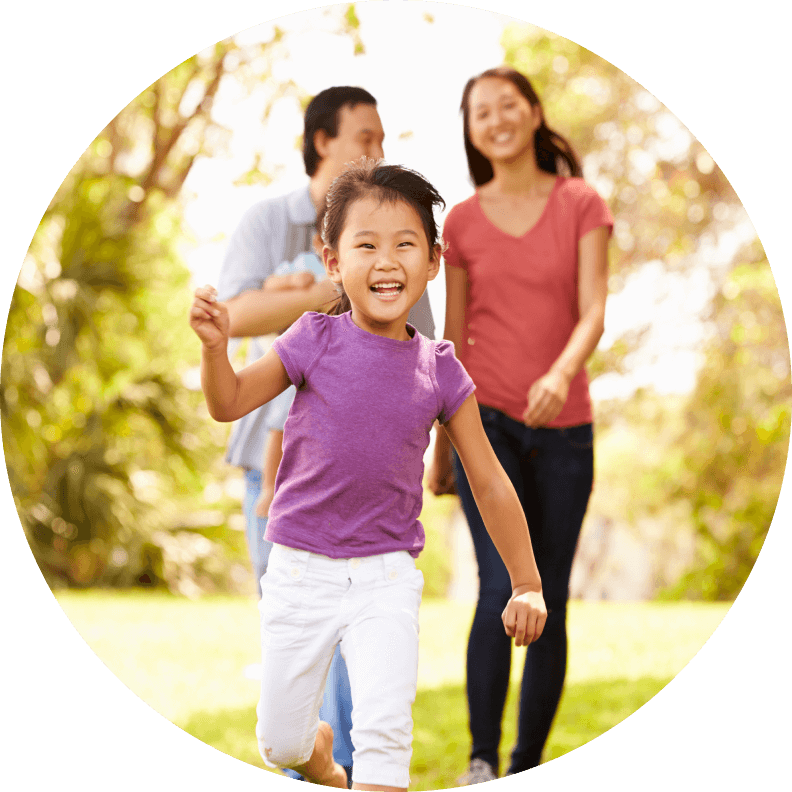 Daughter and parents walking in a park.