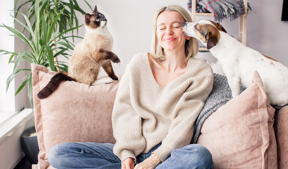 Woman sitting with her cat and dog