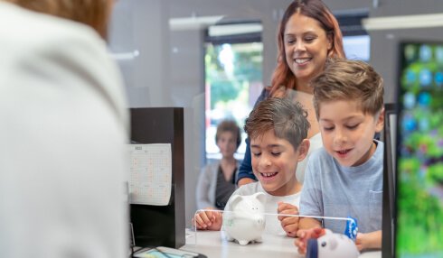 Women with children visiting bank teller