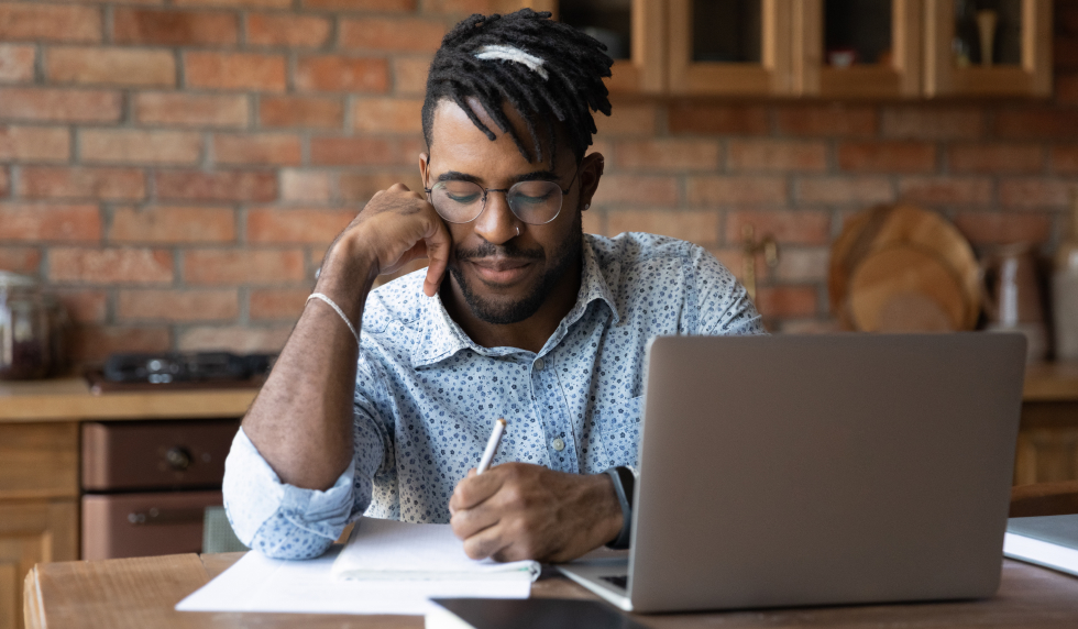 Man working at computer and writing something down