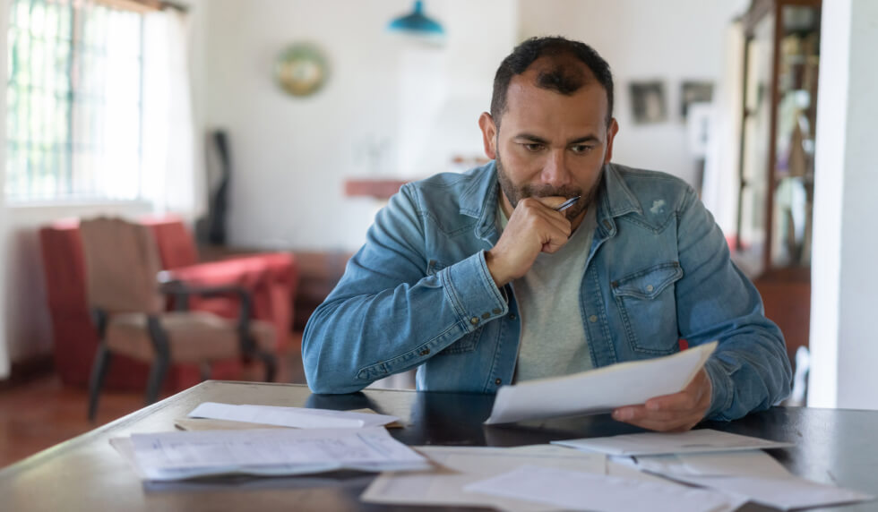 Man thinking with paperwork