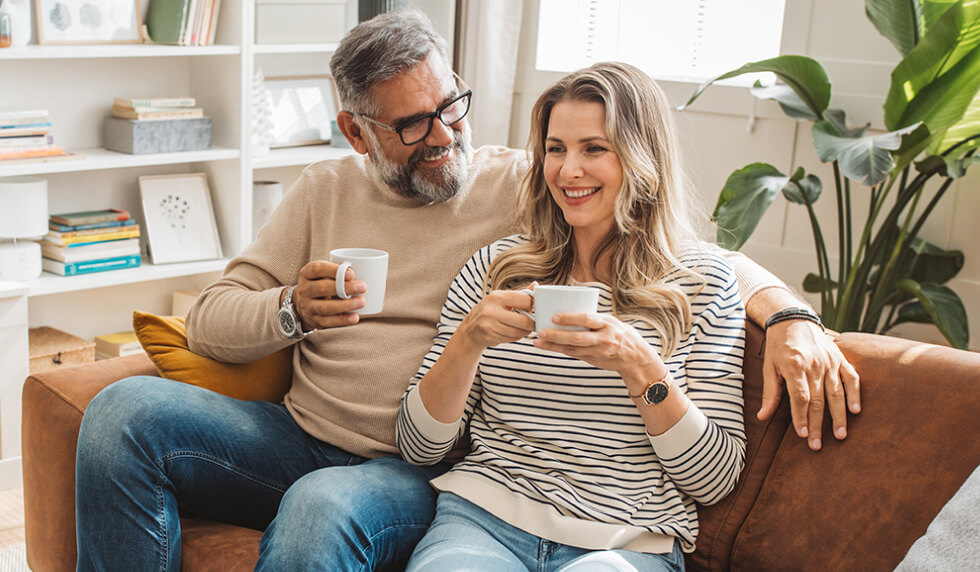Couple sitting on a couch with coffee