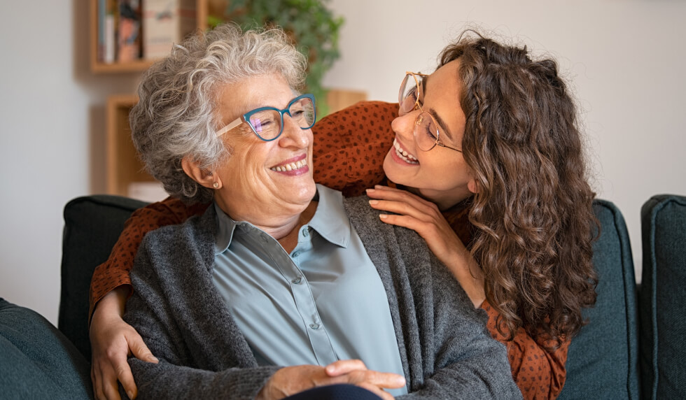 younger woman hugging an elderly woman