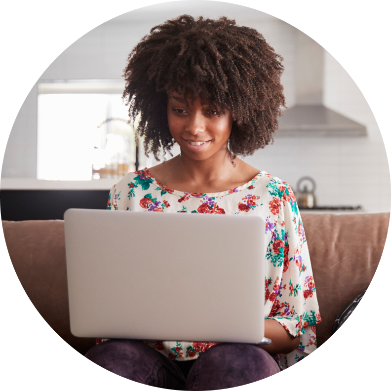 Woman sitting on a couch holding a laptop computer