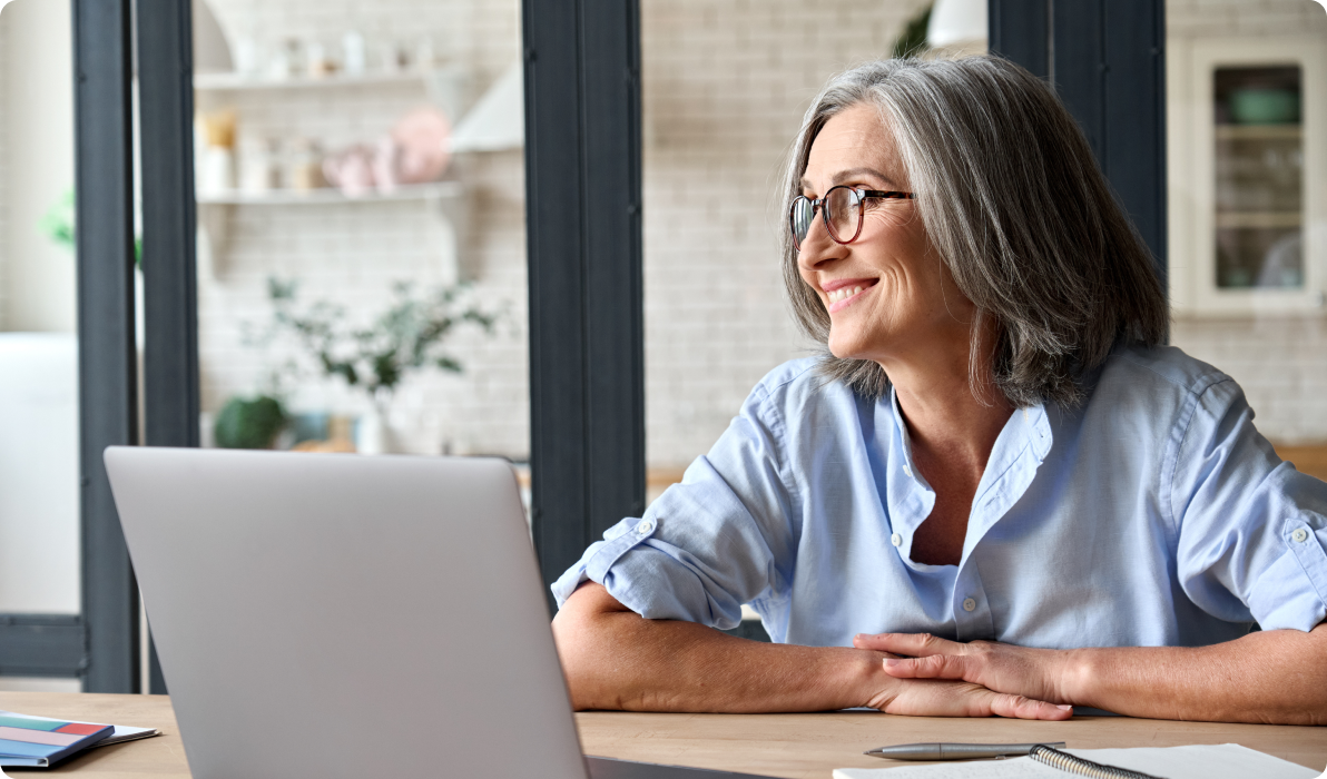 older woman at desk with computer dazing